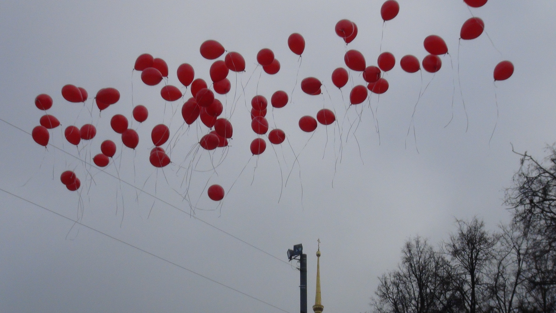 Красный отпускать. Красные шары в небе. Красный шарик на улице. Красный воздушный шарик в небе. Демонстрация с воздушными шариками.